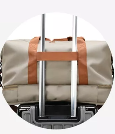 Cream weekender bag placed on top of a suitcase, showcasing its back view with smart organizational compartments and a sleek design, ideal for convenient and stylish travel